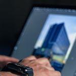 Detail shot of hands typing on a laptop with a smartwatch in view, perfect for tech themes.